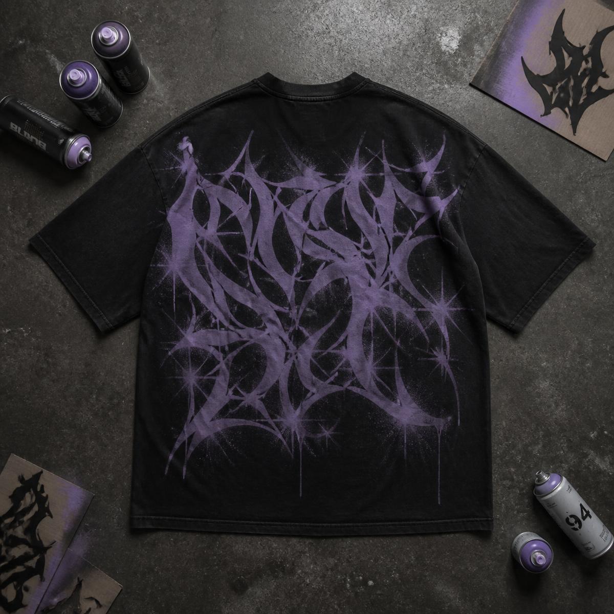 Camiseta oversize negra con aerografía morada sobre concreto, rodeada de latas y plantillas